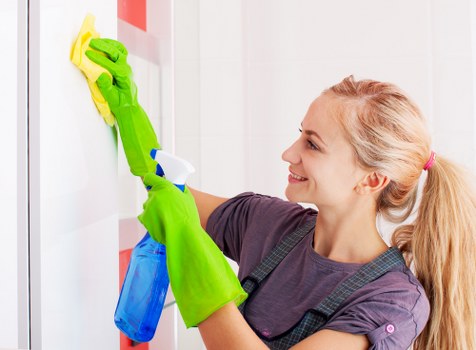Professional home cleaner preparing a tidy Hackney living room